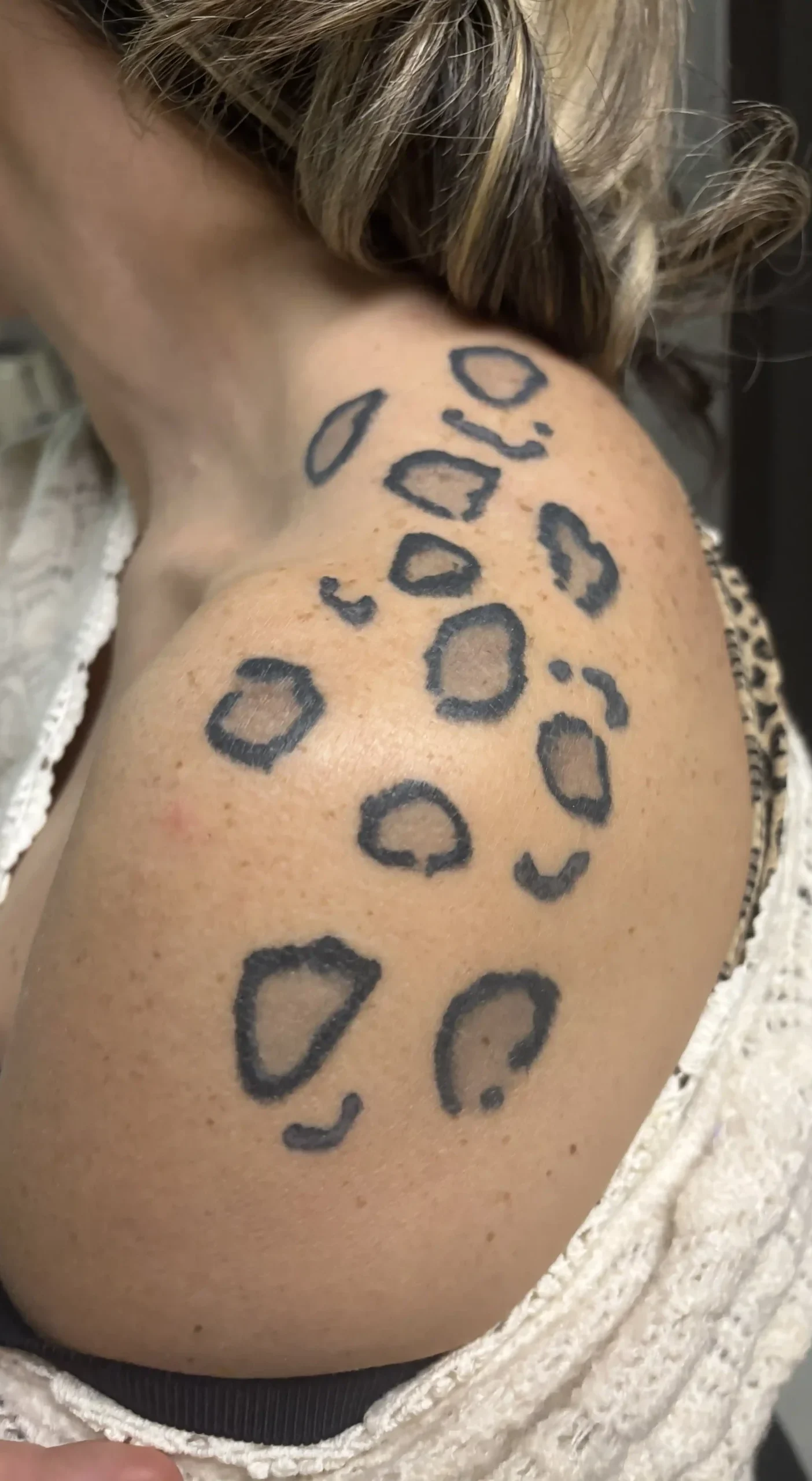 Tatouage taches de léopard sur une épaule de femme par La Griffe