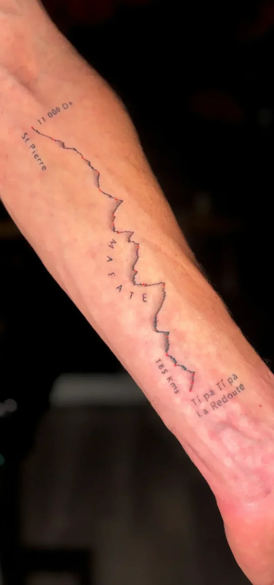 Tatouage fin stylisé tracé de montagne parcours de Trail salon de tatouage la griffe